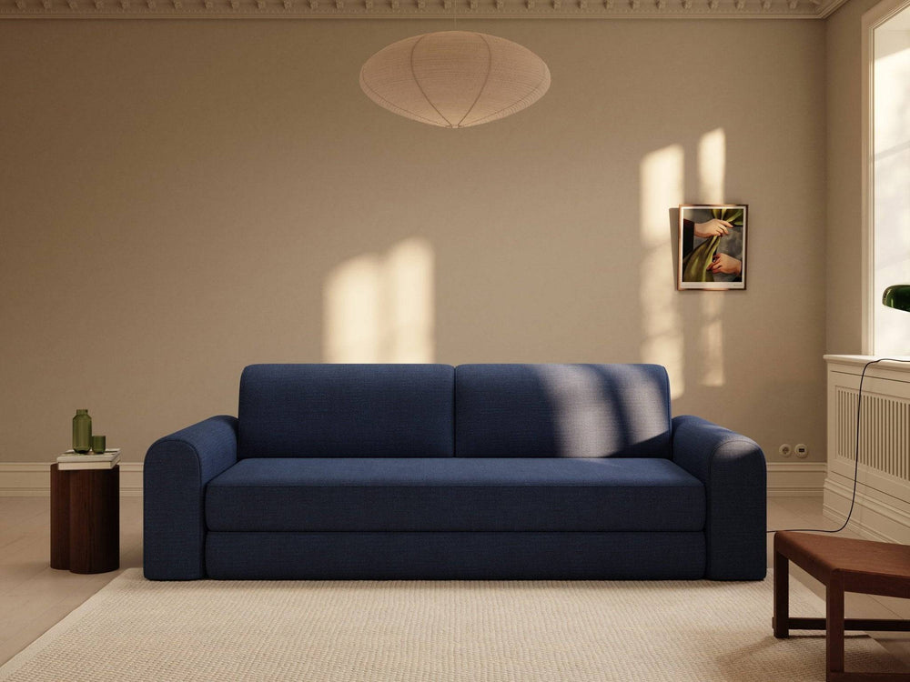 Dyb blå 200x200 cm sovesofa i tætvævet stof, afrundede armlæn og enkel, boxy form i roligt stuedekor.