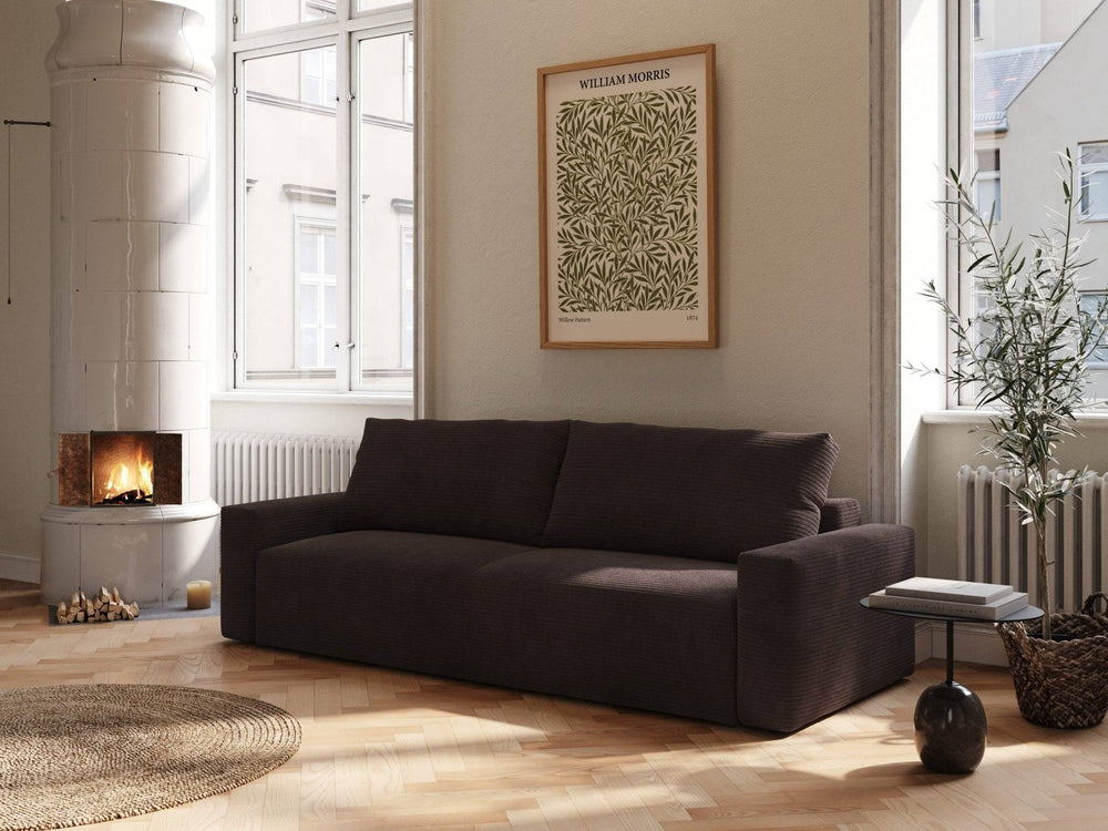Mørk choco-fløjl sovesofa 145x200 cm med bløde, afrundede former i lyst, nordisk stueinteriør ved pejs.