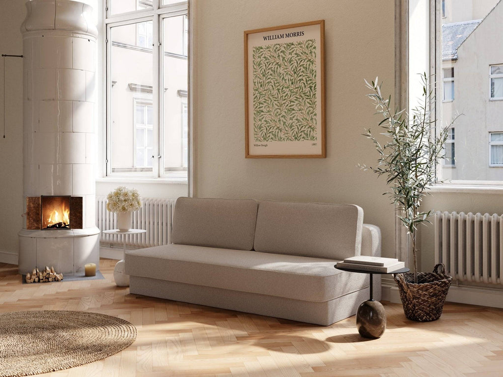 Beige bouclé sovesofa 140x200 cm i lyst rum, lav ryg, bløde former, ved ovn, tæppe og plante.
