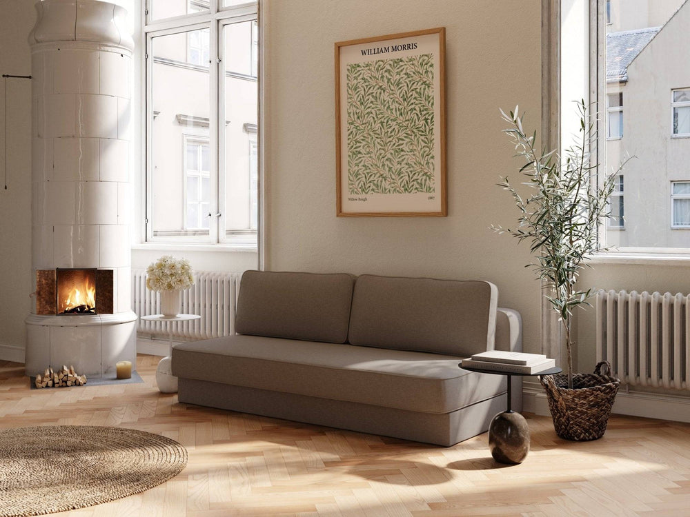 Brun sovesofa 140x200 cm i stof, enkel pude‑ryg, lav moderne form i lyst, skandinavisk stuerum med pejs og plante.