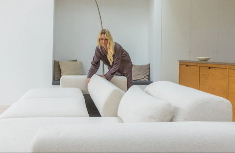 Hvid boucle-modulsofa med bløde, afrundede ryghynder og tekstureret stof i lyst, minimalistisk rum.