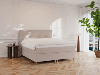 Beige kontinentalseng "Alva" 160x200 med polstret hovedgærde, hvid dyne, gyldne ben i lyst, minimalistisk soveværelse