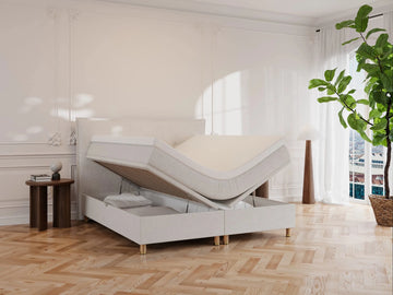 Kontinentalseng Alva 160x200 i cream bouclé, løftbart topmadras og opbevaringsbund, lyse træben, elegant